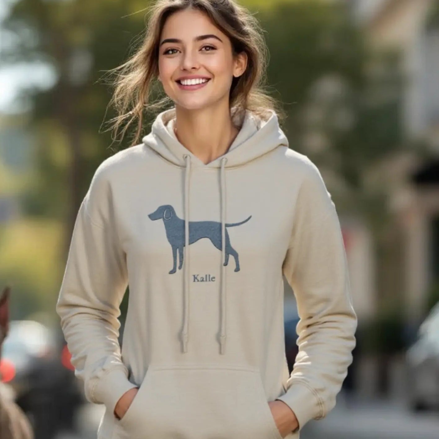 Eine Frau trägt einen Hoodie mit einem Weimaraner