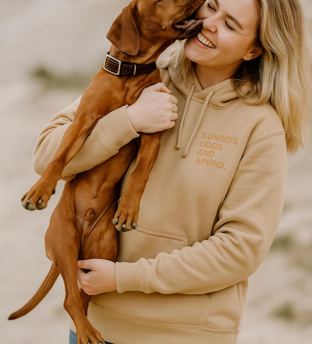 eine frau trägt einen eigen hoodie und hat einen hund auf dem arm