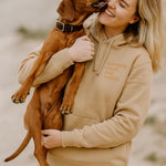 eine frau trägt einen eigen hoodie und hat einen hund auf dem arm